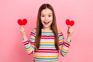Portrait of cute funky little kid daughter hold two red paper postcards surprised happy valentine day isolated on pink color background