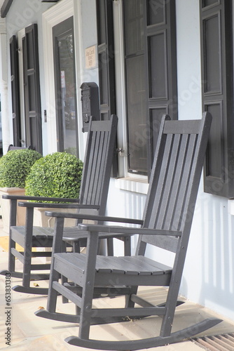 Two black rocking chairs on  the porch.