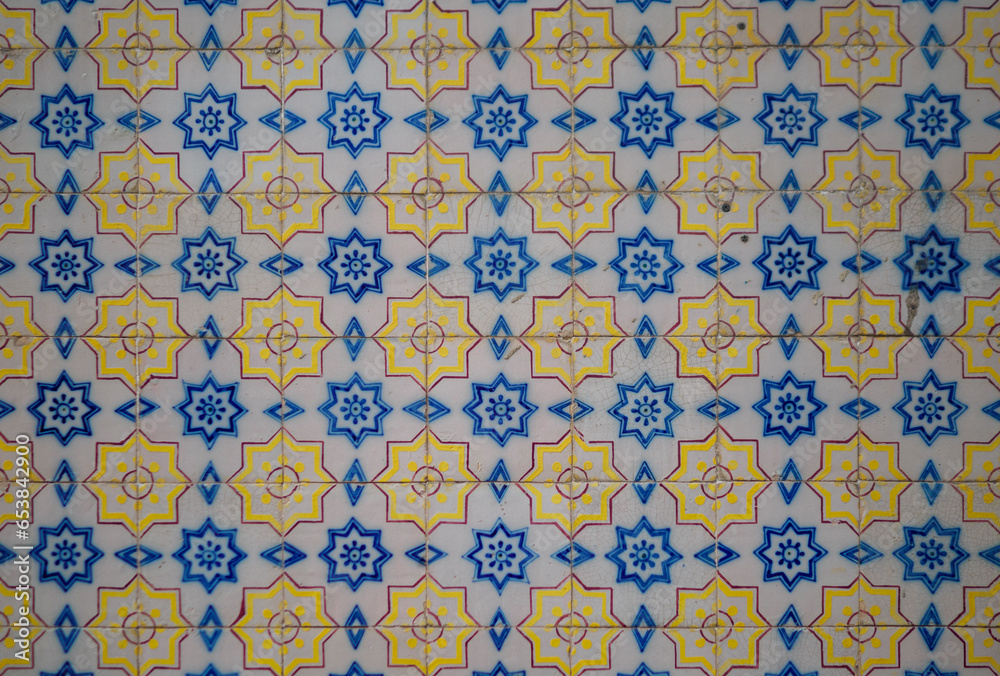 Part of a typical Portuguese wall decorated with tiles. Nice blue, yellow, maroon and white colors. Portugal. Horizontal photo.