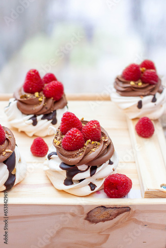 Mini cakes with whipped cream, chocolate, meringue and fresh raspberries. Confectionery poster for cafe or restaurant