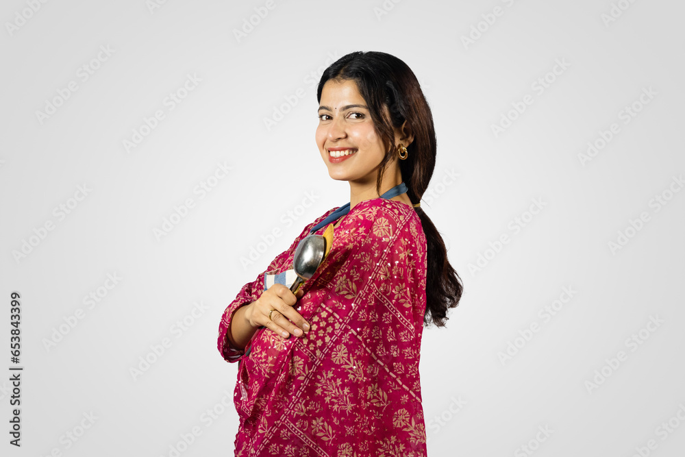 Beautiful Nepalese Indian Housewife in Kurthi, Apron with Kitchen Utensils Smiling, Giving Gestures Beautiful Nepalese Indian Housewife in Kurthi, Apron with Kitchen Utensils Smiling, Giving Gestures