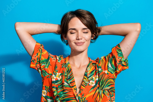 Portrait of gorgeous positive sleepy person closed eyes arms behind head isolated on blue color background