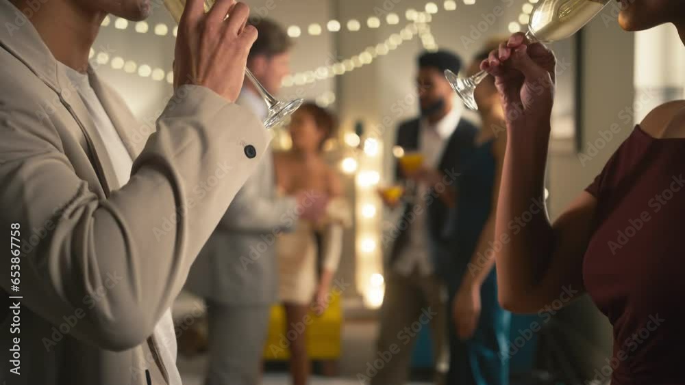 Close up of couple at party at home making champagne toast together with guests in background - shot in slow motion Close up of couple at party at home making champagne toast together with guests in background - shot in slow motion