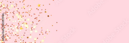 Banner with golden stars and crystals confetti on a pink pastel background. Festive concept. Selective focus.