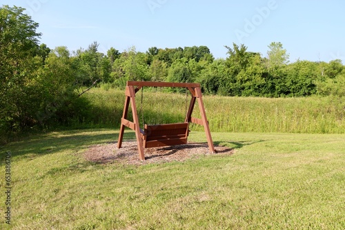 The old wood swinging park bench in the park.