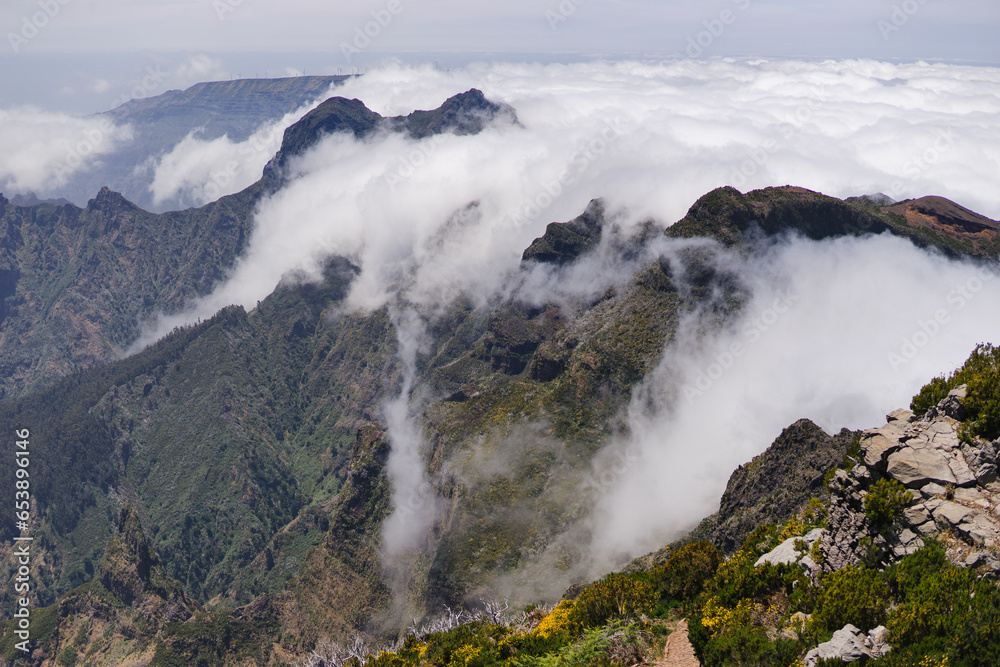 Travelling and exploring Madeira island landscapes or famous places. Summer tourism by Atlantic ocean and mountains. Outdoor view on beautiful sky, cliffs and travel destination. Hiking To Pico Ruivo Travelling and exploring Madeira island landscapes or famous places. Summer tourism by Atlantic ocean and mountains. Outdoor view on beautiful sky, cliffs and travel destination. Hiking To Pico Ruivo