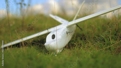 a radio-controlled plane made of extruded foam is lying on the grass