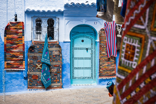 colorful blue wall and carpets on the streets of Chefchaouen Morocco © Agata Kadar