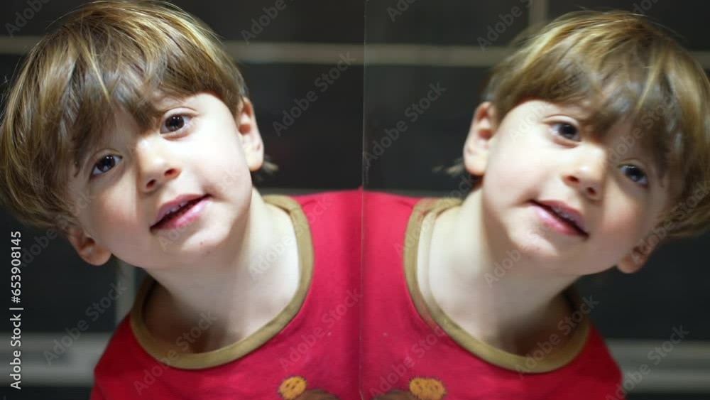 Funny young boy duplicate face in front in bathroom mirror reflection, close-up happy kid looking at camera leaning on reflection Funny young boy duplicate face in front in bathroom mirror reflection, close-up happy kid looking at camera leaning on reflection