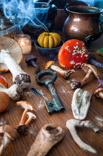 Space with gifferent types of mushrooms, and mortar, and lighted candle on a black table. Esoteric, alternative medicine, aromatherapy or Wicca still life with incense smoke. photo