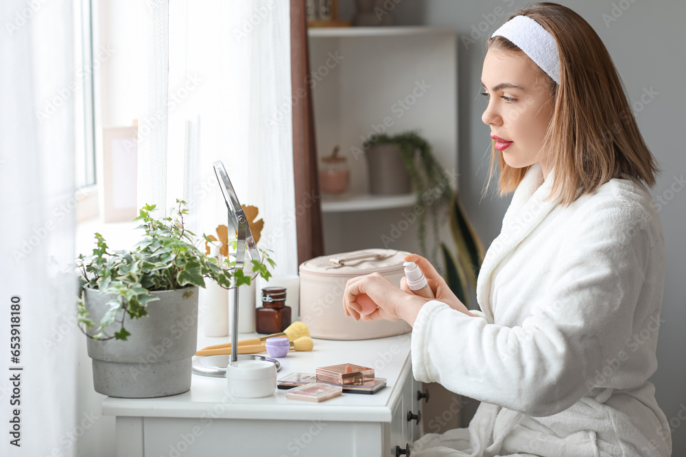 Young woman applying makeup foundation onto her hand at home Young woman applying makeup foundation onto her hand at home