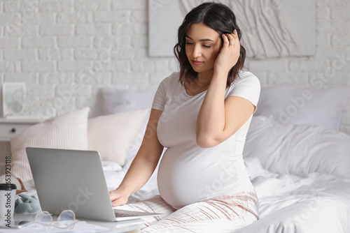 Young pregnant woman workin...