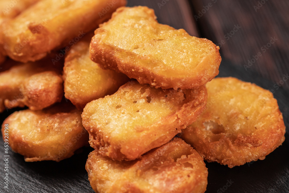 Fried chicken pieces on stone board with chopsticks - asian food close-up Fried chicken pieces on stone board with chopsticks - asian food close-up
