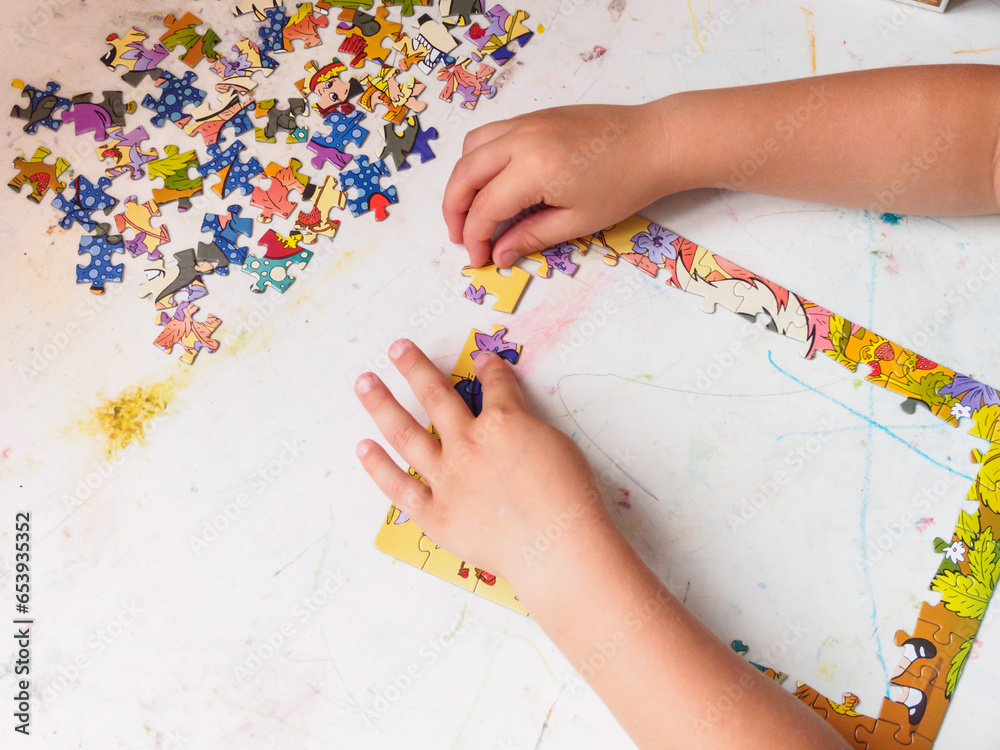 A child plays puzzles, collects a picture, development of brain motor skills, process, early development, close-ups A child plays puzzles, collects a picture, development of brain motor skills, process, early development, close-ups