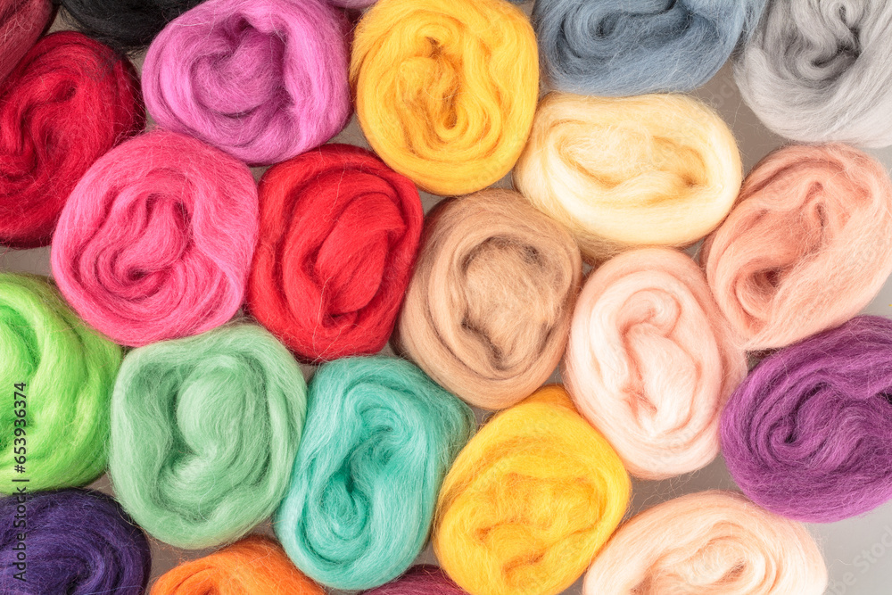 Natural wool fiber in the Balls of different bright beautiful color merino wool for handmade knitting felting close-up Natural wool fiber in the Balls of different bright beautiful color merino wool for handmade knitting felting close-up