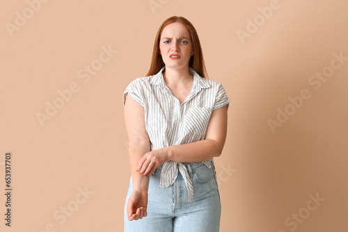 Allergic young woman scratc...