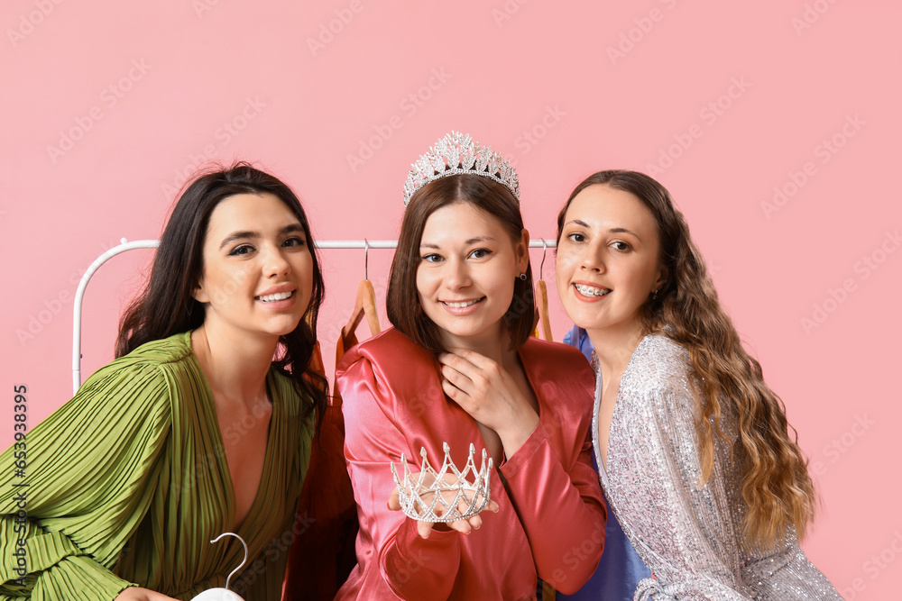 Obraz premium Young women with tiaras for prom on pink background