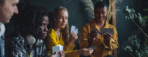 Diverse group of young people, friends, college students gathering together, have fun, playing games, laughing. Concept of diversity, international friendship, learning foreign languages banner photo