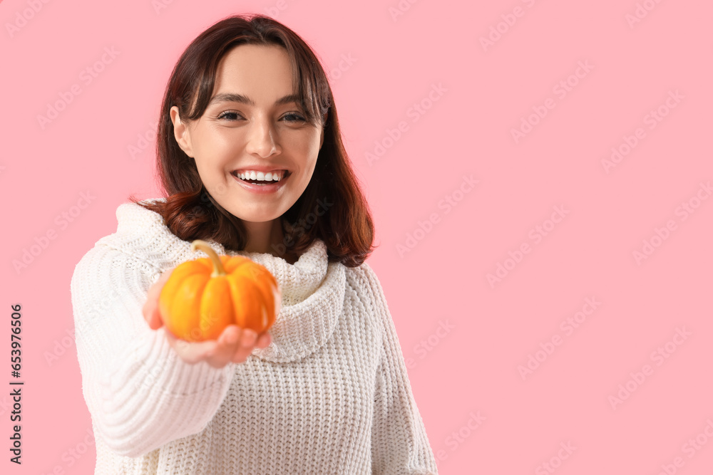 Young woman with pumpkin on pink background, closeup Young woman with pumpkin on pink background, closeup