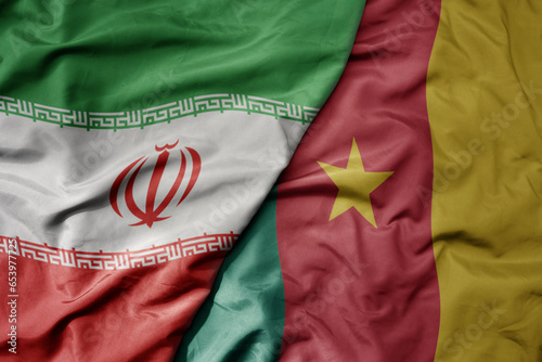 big waving realistic national colorful flag of iran and national flag of cameroon .