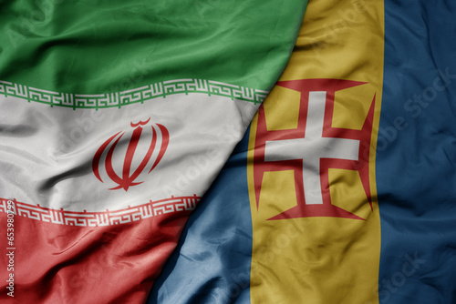 big waving realistic national colorful flag of iran and national flag of madeira .