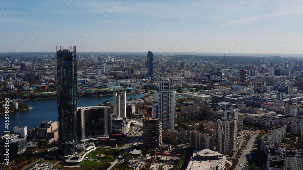 Top view of beautiful city with modern buildings and river. Stock footage. Beautiful city with river and buildings on summer day. River in modern city on background of horizon