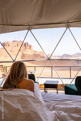 Naked blonde tourist woman in the bed sheets into bubble tent at Wadi Rum protected area desert Jordan © Nestor