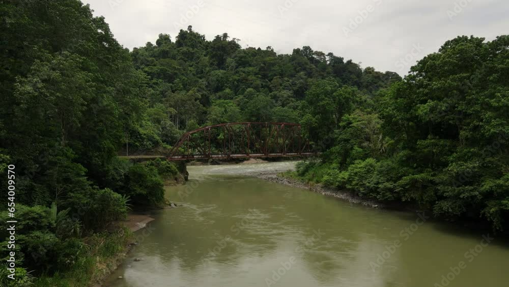Aerial shot of an old rusty metal bridge over a river in Costa Rica Aerial shot of an old rusty metal bridge over a river in Costa Rica