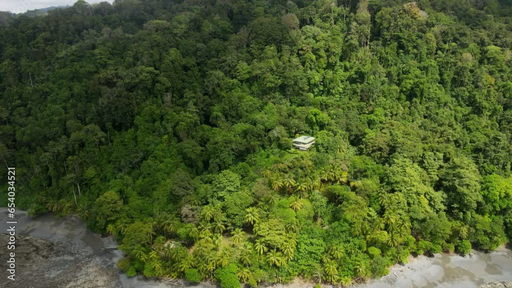 Aerial shot of a house lost in the middle of the jungle and mountains in Costa Rica.