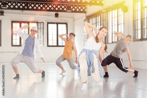 Emotional teenage dancers having hip-hop dance training at dance hall