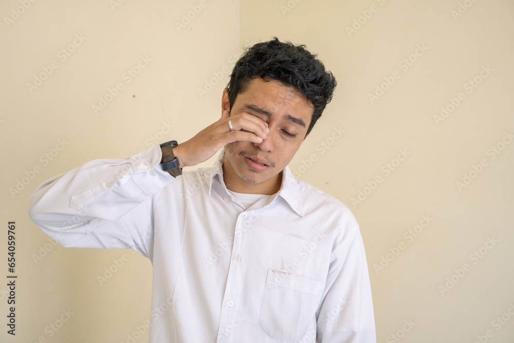 Young Indonesian curly man wear white clothes with sleepy face pose. The photo is suitable to use for man expression advertising and fashion life style. Young Indonesian curly man wear white clothes with sleepy face pose. The photo is suitable to use for man expression advertising and fashion life style.