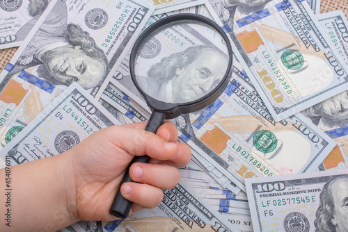 Magnifying glass over the banknote bundle of US dollar