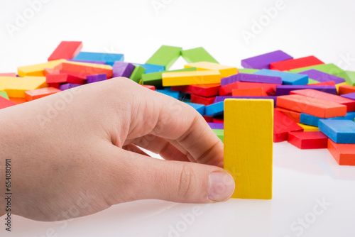 Hand playing with colored domino photo