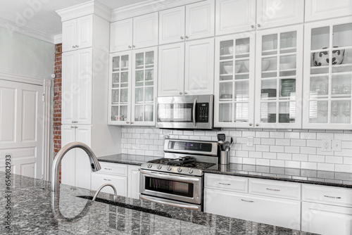 Картината върху платно Modern White Kitchen Interior with Exposed Brick Wall and Subway Tile and Glass