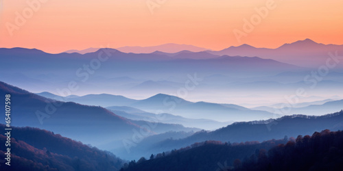 The mountains are shrouded in mist. A twilight shot of autumn mountains under a fading red orange purple sky. © red_orange_stock