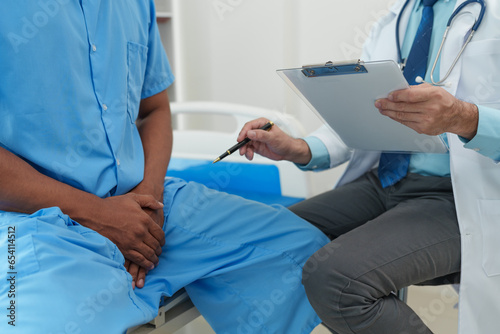 Papier peint A male doctor is inquiring about the testicular cancer test report of a male patient for diagnosis and planning