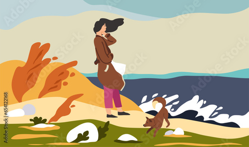 Woman standing by sea with dog in autumn season