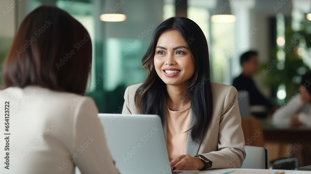 Thai mature group businesswoman using laptop smile talking with friend in the white office