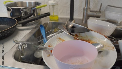 pile of dirty dishes in the kitchen sink, washing kitchenware at home