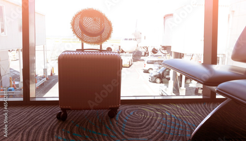 Travel concept with pink luggage as hat in the airport terminal waiting area, summer vacation concept, traveling and enjoying concept © SASITHORN