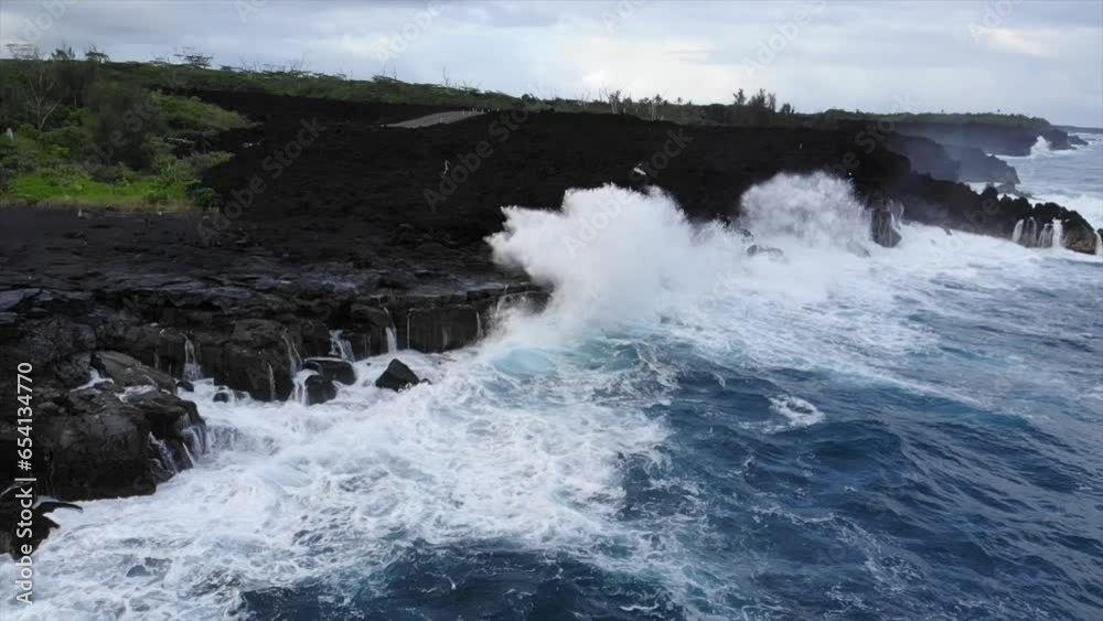 Rotating view of waves hitting cliffs from ocean perspective showing forest and volcanic flow Rotating view of waves hitting cliffs from ocean perspective showing forest and volcanic flow