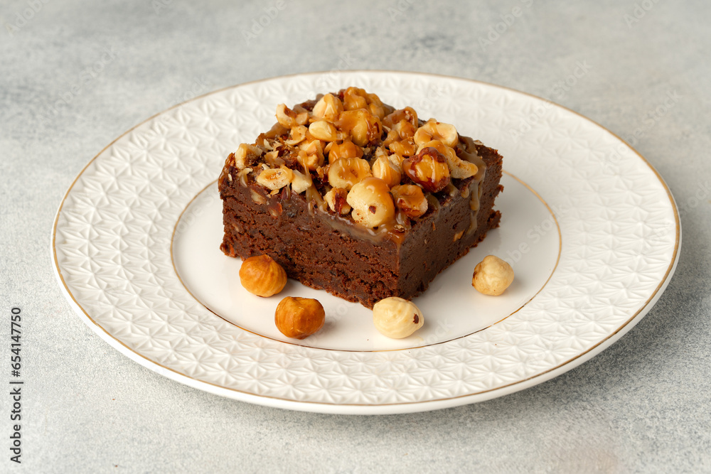 Brownie cake with nuts topping on plate close up Brownie cake with nuts topping on plate close up
