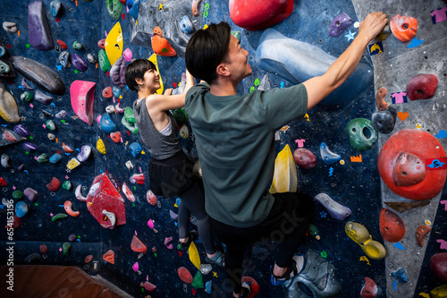 Canvas Print A man and a woman enjoy bouldering in a gym