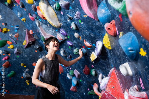 Beautiful woman enjoying bouldering at a bouldering gym. Healthy living. Physical and mental wellness.