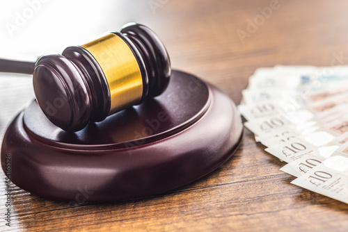 Judge gavel and british pound sterling on wooden table. photo