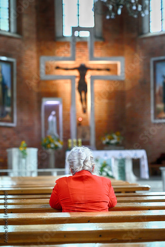 Stara kobieta w kościelnej ławie samotna. 