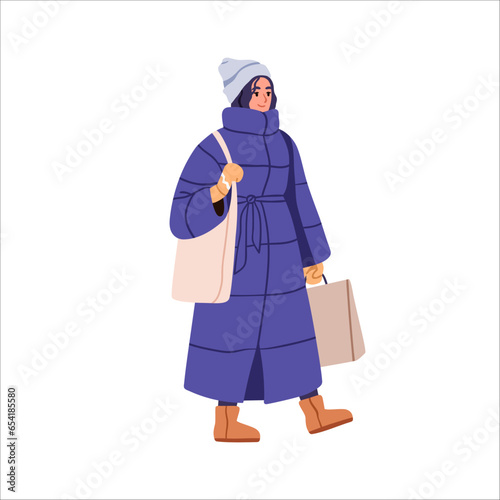 Woman in winter apparel, long puffer coat, hat. Modern girl walking with tote and shopping bags. Female in warm outfit for cold weather. Flat graphic vector illustration isolated on white background