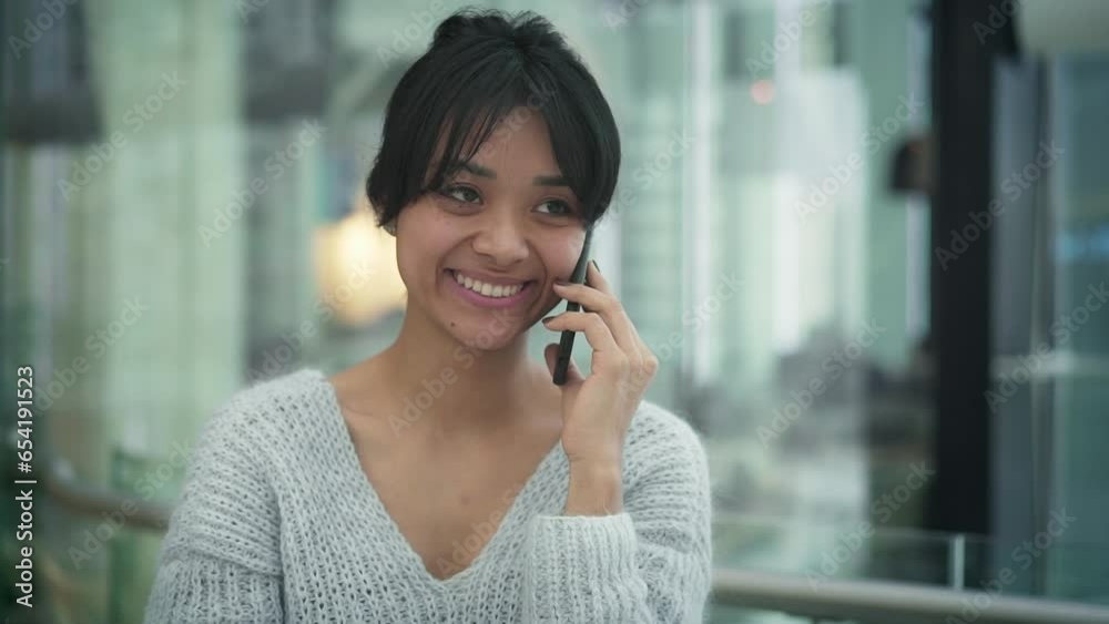 Portrait shot of happy smiling asian young woman chatting on the phone, walking alongside the open space common area of business center. Close up of asian girl having a call Portrait shot of happy smiling asian young woman chatting on the phone, walking alongside the open space common area of business center. Close up of asian girl having a call