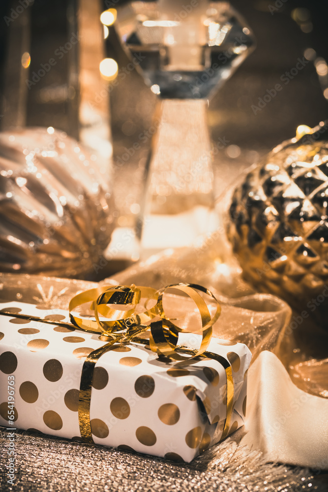 Close-up of gift, baubles and decoration on a table decorated for Christmas, warm gold colors, vertical