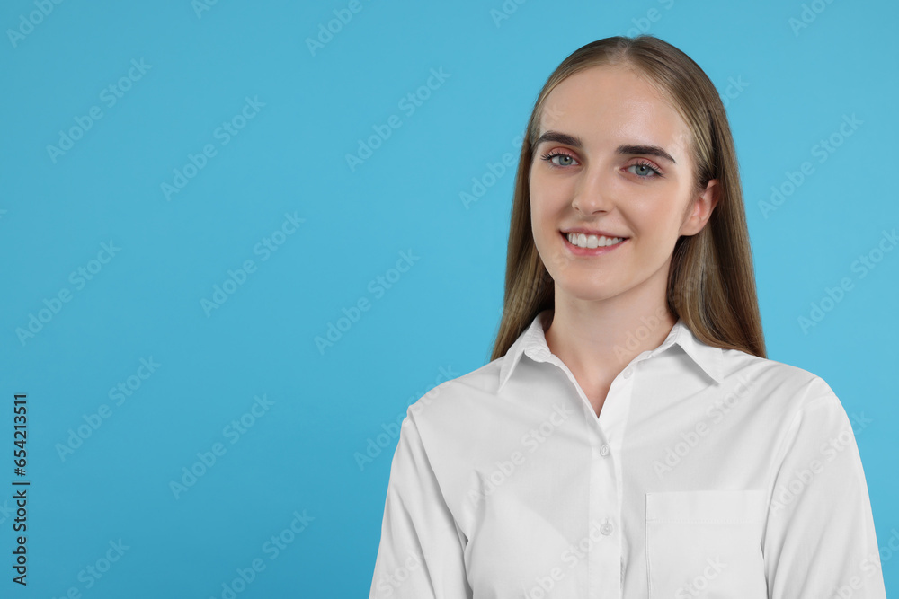 Portrait of happy young secretary on light blue background, space for text Portrait of happy young secretary on light blue background, space for text